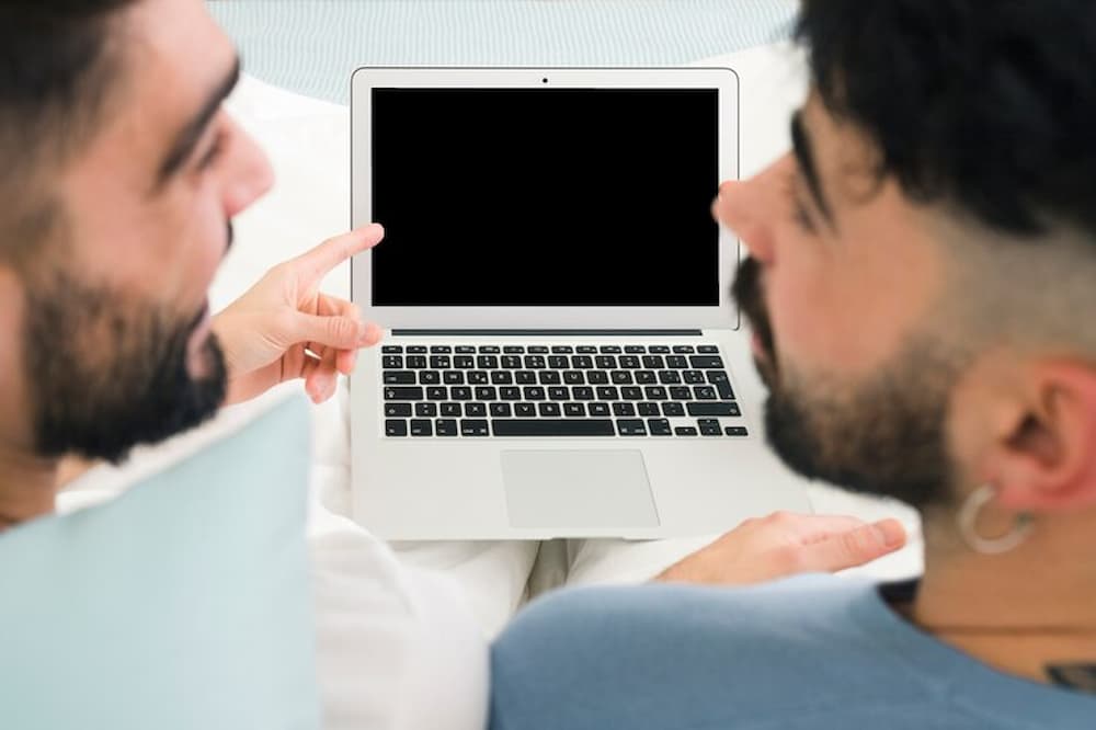 hombres realizando trámite en laptop