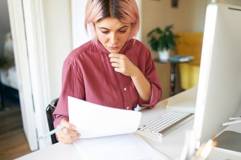 Mujer en escritorio leyendo documentos